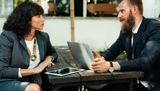 Two persons working on a laptop