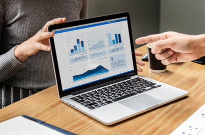 laptop displaying various colorful business graphs and charts on its screen